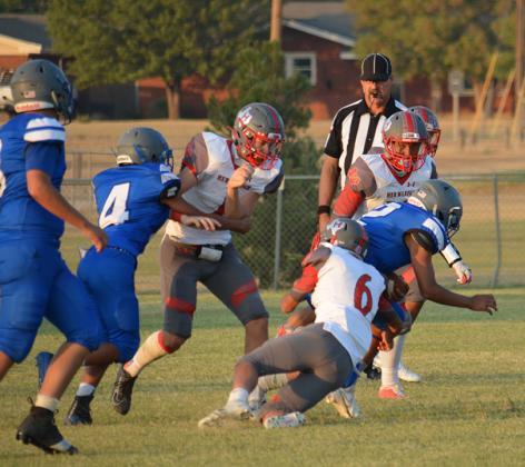 In the waning moments of Friday night’s game, Hermleigh defenders (l-r) Stetson Digby (1), Mateo Clement (6) and Zane Nachlinger (12) wrap up a Wilson Mustangs ball carrier. The Cardinals emerged victorious 54-0.