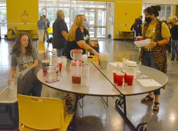 Sarah Walters (left) and Sarah Smith (center) from Sideline Nutrition served samples of tea to new teacher Sharon Whittenburg at Snyder ISD’s Meet Snyder Vendor Fair while other new teachers visited tables set up by other local businesses.