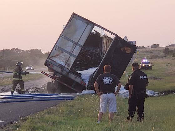 Snyder volunteer firefighter Rustin Webb (left) hosed down an overturned 18-wheeler Saturday evening near the intersection of U.S. Hwy. 84 and U.S. Hwy. 180. Also pictured are truck driver Jonathan Taylor (center) and Snyder Police Officer Sabrina Salinas.