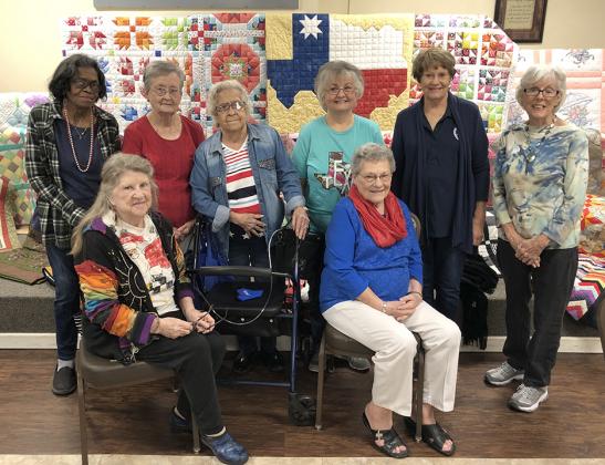Senior Center quilters (l-r) Bonnie Wallace, Ruth Morrell, Anna Poe, Norma Callaway, Pat Pylant, Rosa Lee Crow, Carolyn Smith and Gaynel Cline posed with all of the quilts they created in the past year. The quilts will be displayed in shops around Snyder and sold at the May Day on the Square auction on September 26.