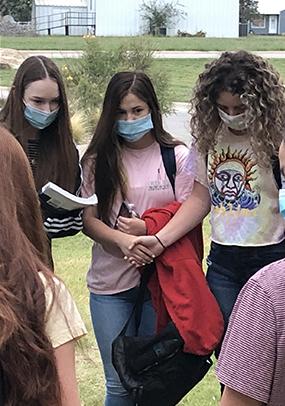 Ira High School students (l-r) Emily Lowry, Heidi Sanchez and Bailey Hall prayed with a larger group at Ira ISD’s See You at the Pole rally Wednesday.