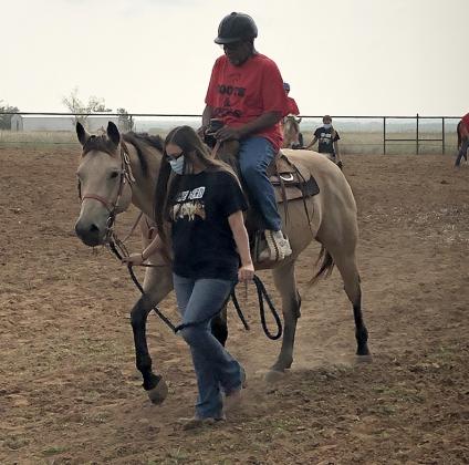 Texas Tech Therapeutic Riding Center employee Deanna Davila assisted veteran Joe Jaure in learning riding basics at the Boots and Spurs event.