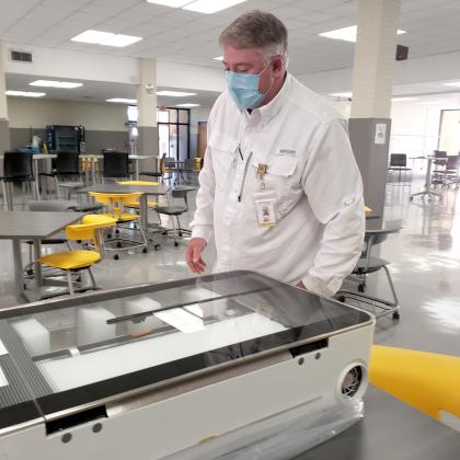 Science, Technology, Engineering and Math (STEM) Coordinator Scott Whittenburg examines a new Glowforge laser cutting and etching machine in Snyder High School’s new Makerspace.