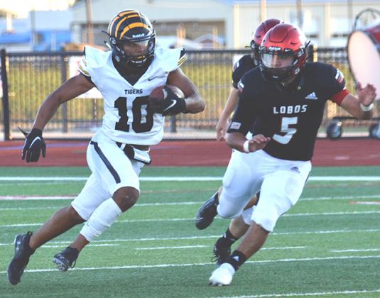 Snyder junior Cameron Smith (left) ran away from Levelland defender Angel Camaro during the Tigers’ 26-10 loss at Lobo Stadium Friday. Smith finished with 116 total yards of offense.
