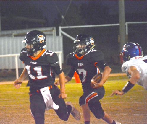Quarterback Bryton Partain (11) leads running back Ike Weaver in a run during Ira’s game vs. Knox City Friday. This week, the Bulldogs travel to Roscoe to face the Highland Hornets.