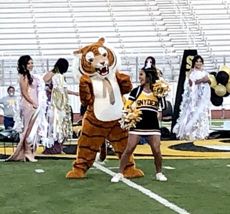 “T” the Tiger dances with cheerleaders as Homecoming Queen candidates look on. While there was no game Friday evening, the newly crowned king and queen, along with their court, will sit enthroned on the track during the Tigers’ next home football game.