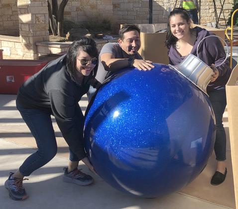 Chamber of Commerce staff members (l-r) Sandra Salinas, Josh Ortegon and Summer Grimmett unboxed decorations Tuesday at the Pocket Park on the Courthouse Square.