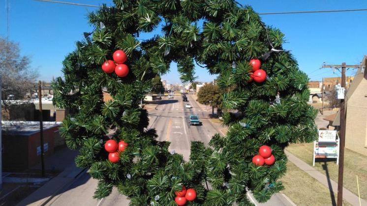 Members of the Snyder Professional Firefighters’ Association hung Christmas decorations along College Avenue Tuesday. 