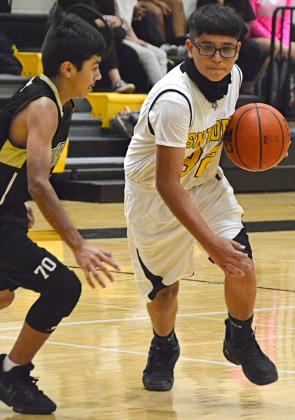 Snyder eight grader Cesar Lara-Cruz (right) drove past a Big Spring defender during a game in the Snyder Junior High School gym Monday. All four SJHS boys teams won against Big Spring on Monday.