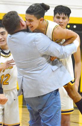 Snyder senior Christian Escobedo (right) was lifted by assistant coach Dustin Murrow after Escobedo made the free throw that sealed the win.