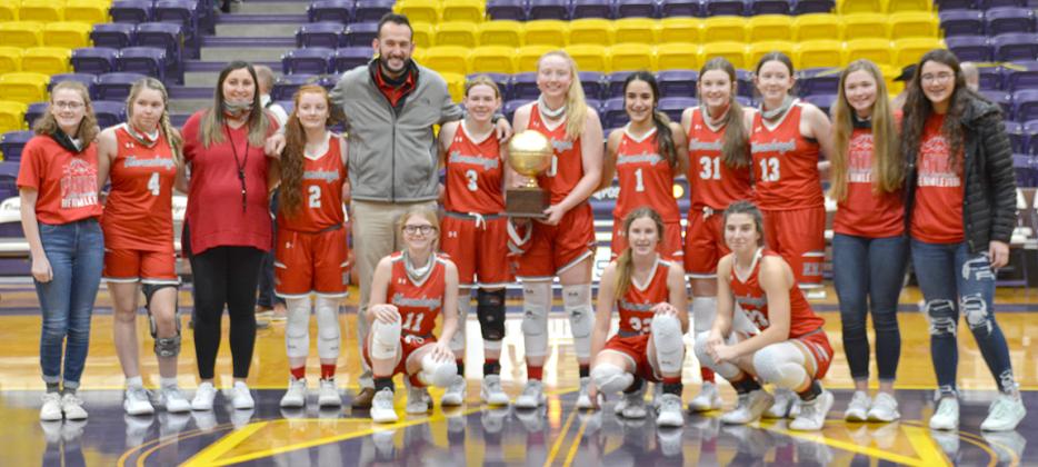 Hermleigh Lady Cardinal basketball team posed with the bi-district trophy after defeating Cross Plains, 48-38 at Merkel High School on Friday