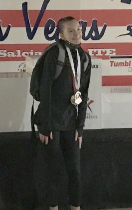 Wiggins posed with her gold medal at a gymnastics competition.