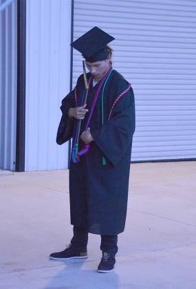 Snyder High School graduate Temo Olvera adjusted his cords before Friday’s graduation ceremony.