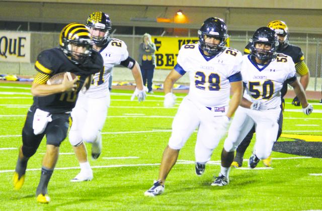 Snyder quarterback Logan Tate (10) runs away from Stephenville defenders during Friday’s game at Tiger Stadium.