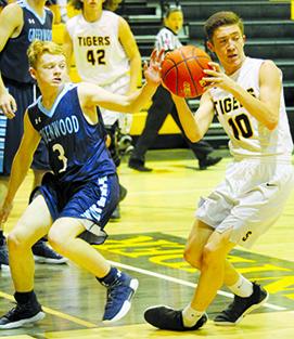Snyder’s Kobe Roemisch (10) makes a move against Midland Greenwood’s Cameron Jones during Tuesday’s game. The Tigers defeated Greenwood, 52-50.