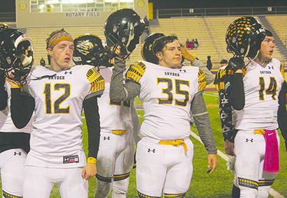 Snyder seniors Logan McGinnis (12), Eric Rinehart (35) and Nathan Kendrick (14) lifted their helmets in victory at the end of Friday’s game at Pecos.