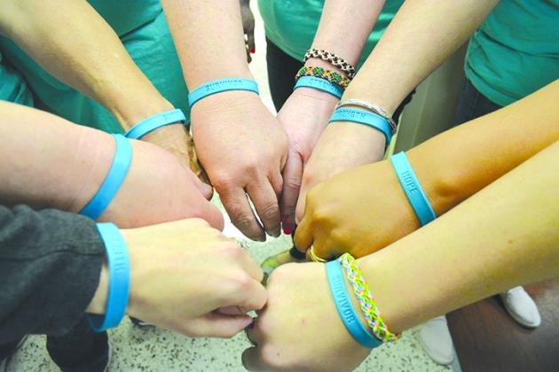Cogdell Memorial Hospital staff members display bracelets worn in observance of Sexual Assault Awareness Month.