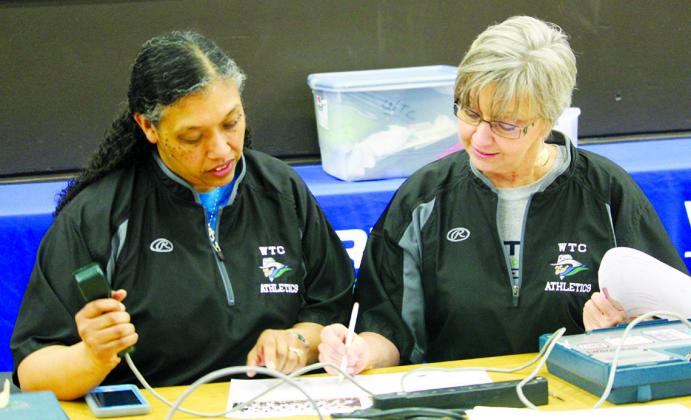 Freda Malone (left) and Rhonda Ward double check the rosters prior to a Western Texas College basketball game at The Coliseum. Malone has been operating the shot clock at WTC games for several years and watched her daughter, Zoi, play for the Lady Westerners.