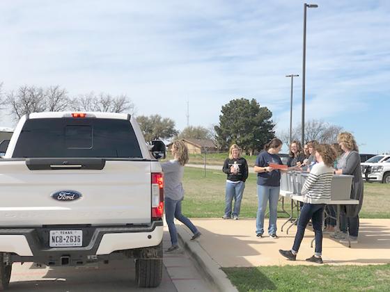 A group of Ira teachers handed out packets to parents. Pictured on the left is kindergarten teacher Candice Poole and in front of the table are junior high school science teacher and coach Marcy Reneau, instructional aide Macy Garcia, and secretary Keva Fowlkes, amongst others.