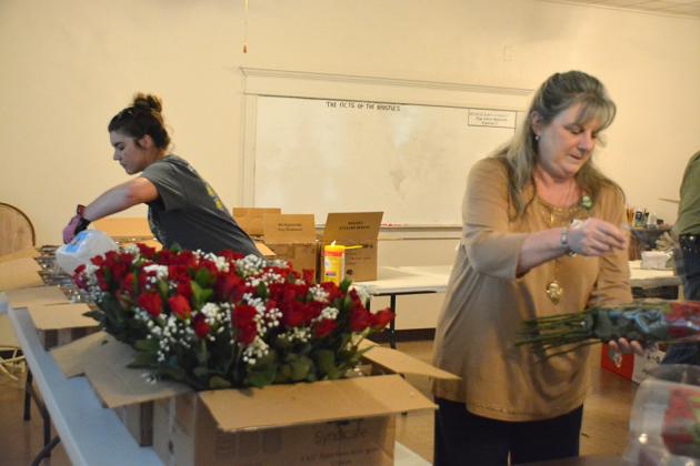 Lions Club members Tara Camp (left) and Rose Ragland prepared bouquets of roses to be delivered for the annual Lions Club fundraiser.