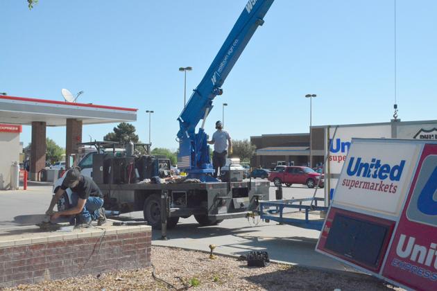 Wellborn Sign Company employees Brendon Asher (left) and Ryan Boyer replaced the United Express gas station sign Wednesday.