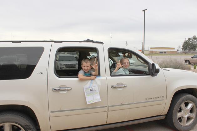 Ira ISD kindergarten student Kolt Jones (left) and his third grade sister Braylee Jones waved to their teachers during packet pick-up.