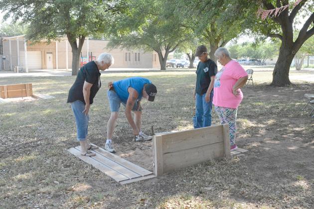 Horseshoe players (l-r) Bernie Sealy, Toby Wright, Lee Birchfield and Maria Carrisales measured the distance between their horseshoes and the stake at a tournament at the Scurry County Senior Center Friday.