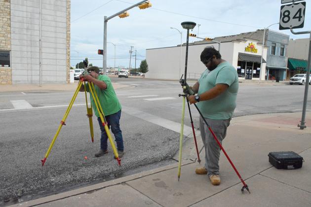 Surveyors Nigel Wilson (left) and Albert Schooley calibrated their equipment to begin surveying College Ave. yesterday.