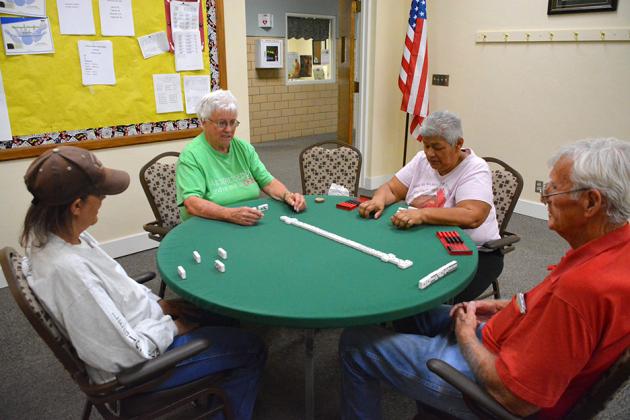 Lee Birchfield, Bernie Sealy, Maria Carrisales and Steve Mize played dominoes together after the reopening of the senior center.