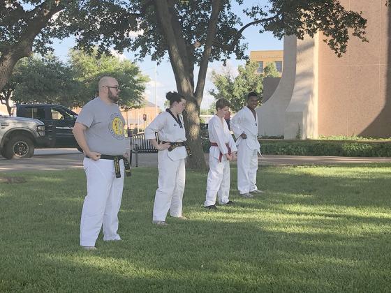 West Texas Taekwondo Academy teacher Charles Underwood and his students (l-r) Jada Odom, Jake Odom and Danin Smith did practice exercises on the courthouse lawn this week.