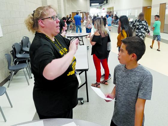 Incoming Snyder Junior High School sixth-grader Nehemiah Vasquez (right) received his schedule from teacher Jennifer Beard during orientation at the school Monday afternoon. Snyder students begin the school year Thursday.
