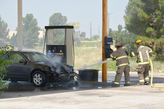 Firefighters Gary Colvin (left) and Russell Smith put out a vehicle fire in the 1100 block of U.S. Hwy. 180 Friday.