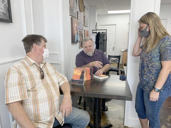 David Miller (center) greeted Ken Spoor (left) and Kaitlin Stewart during a book signing last week at the J316 Downtown Coffee House.
