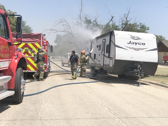 Firefighters Cody Kolecek, Freddy Galvan, and Fire Chief Perry Westmoreland (l-r) put out a camper fire in the 2900 block of Denison Ave. Friday.