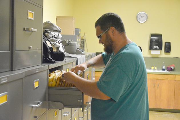 Dustin Shreve, Snyder High School’s new band director, looked through music files during band registration Tuesday.