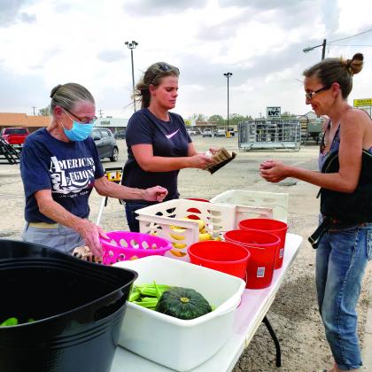 American Legion members Donna Campbell (left) and Jennifer Caffee gave vegetables from the Community Garden to Sandi Sutter.  Legion members will give away vegetables in the Gebo’s parking lot Tuesdays and Thursdays from 3 to 5 p.m. “Of course they can come to the American Legion any time and pick out whatever they like,” Caffee said.