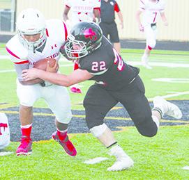Eli Garza attempts to get away from Brenden Fisk of Motley County. The Cardinals lost to Motley County 34-23 in Saturday’s season opener.