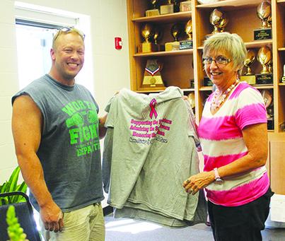 Michael Humphrey (left) picked up his Friday Night Fight for Cancer pink out T-shirt from Rhonda Ward Thursday. The Snyder Tigers will celebrate pink out night when they host the Sweetwater Mustangs at Tiger Stadium today. Proceeds will benefit the Snyder cancer fund.