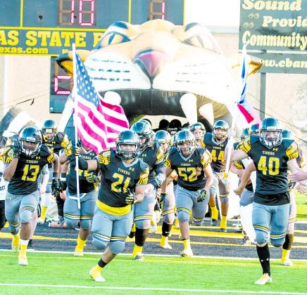 Avian Gutierrez (21) and Braison Kuhl (40) led the Snyder football team onto the field last week holding the American and Texas flag, respectively. The Tigers will host Muleshoe for Freedom Friday Night at 7:30 p.m. today. Snyder High School alumni who are veterans or active duty military will be honored during pregame festivities.