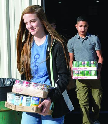 Snyder High School freshmen Jordan Phillips (left) and Drevian Hernandez helped load canned goods collected for the Kiwanis Club’s Goodfellows campaign.