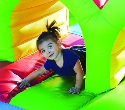 Evii-Lou Garcia, 1, played in an inflatable obstacle course at National Night Out on Tuesday night at the Villages at Snyder. 