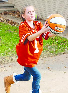 Skyler Reston shoots the basketball and wears a University of Texas Longhorn football jersey she received for Christmas. Reston is the daughter of Scott Reston of Snyder.