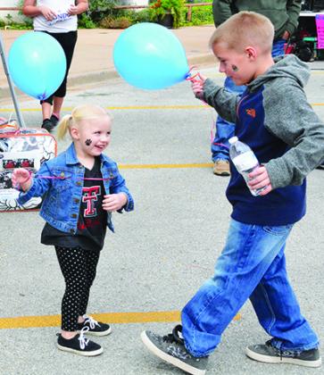 Hadley (left) and Stayton Robbinson played with balloons during White Buffalo Days on Saturday.