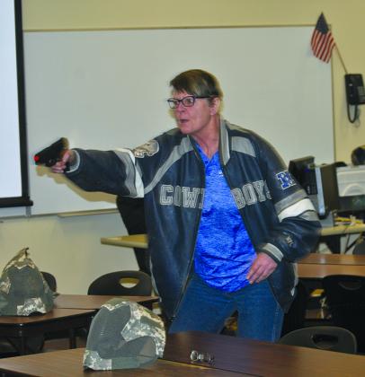 Posing as a gunman, Western Texas College Grant Program Director Stacy Payne takes aim during an active shooter training session at the college Friday morning.
