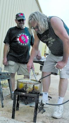 Ray Dering (left) watches as Dennis “Knick” Knucklebone fries a batch of catfish during the American Legion Post No. 181 fish fry Monday evening.