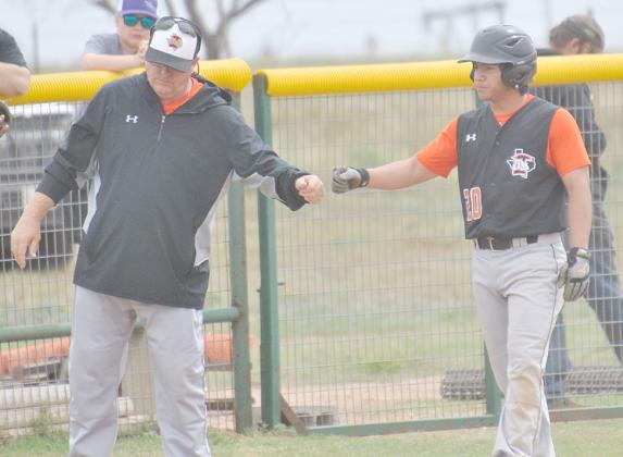Ira head coach Toby Goodwin (left) congratulated Anthony Coy after hitting a triple during the Rotan game earlier this season. The Bulldogs will open a best-of-three Region 1-1A quarterfinal series with Baird at 2 p.m. Thursday at Abilene Chirstian University.