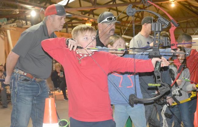 Scurry County 4-H archery program instructors Chuck Barbee (left) and Mike Hale watch as Stayton Robertson (second from left) and Mia Shultz aim at the target during this week’s practice session. Forty youth are participating in the program, which is in its second year of existence.