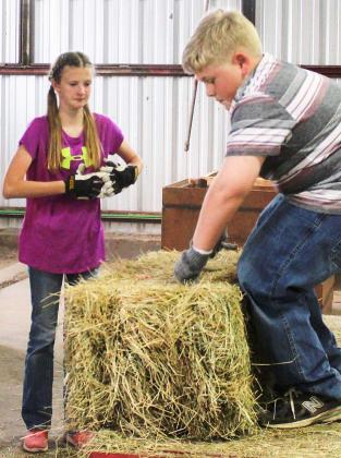 Anzlee Hale (left) and Michael Woodward set up hay targets during 4-H archery sports practice.  