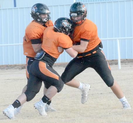Ira’s Asher Fowlkes (center) tried to get free from a double-team block from Holden Rios (left) and Carter Roberson during practice at Bulldog Stadium Wednesday. The Bulldogs will take on White Deer in the area playoffs at Wildcat Stadium in Littlefield, with kick-off set for 7:30 p.m. Friday.