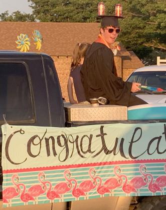 Ira valedictorian Asher Fowlkes sported a unique graduation cap and a water gun as he rode in the parade at Ira ISD